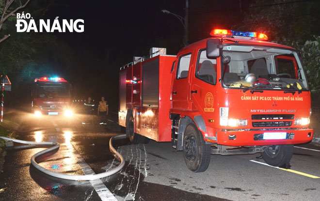 Các xe chữa cháy triển khai phun nước dập lửa cháy thực bì tại ta-luy âm đường lên bãi Bắc, bán đảo Sơn Trà đêm 10-6. 			       Ảnh: HOÀNG HIỆP