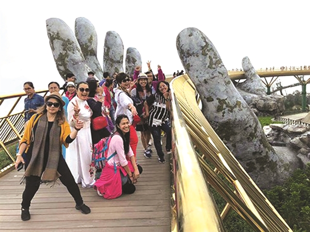 Thai tourists take photos at the Golden Bridge at the Ba Na Hill in Da Nang