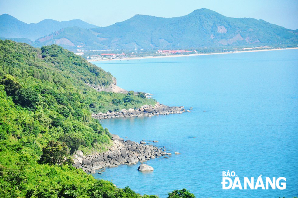 A picture of rock stones and blue sea with mountain background