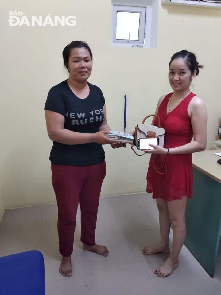 Chị Trần Thị Tri (trái) trao trả lại tài sản cho chị Hoàng Thúy Quỳnh.