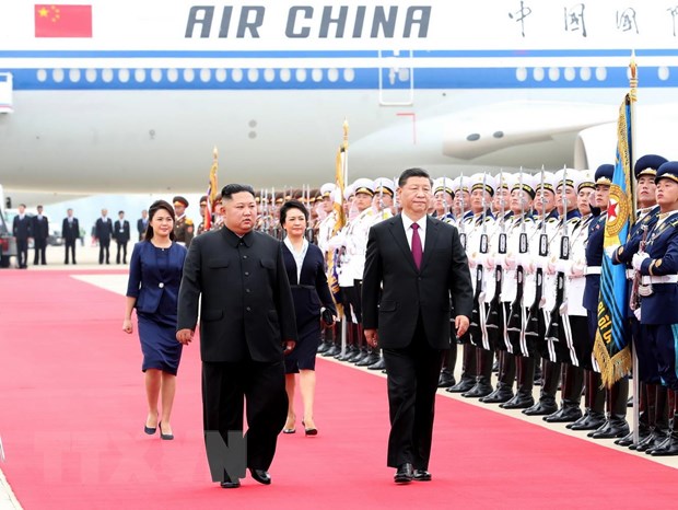 Chủ tịch Trung Quốc Tập Cận Bình (phải) và nhà lãnh đạo Triều Tiên Kim Jong-un (trái) tại lễ đón ở Bình Nhưỡng ngày 20-6. (Ảnh: THX/TTXVN)