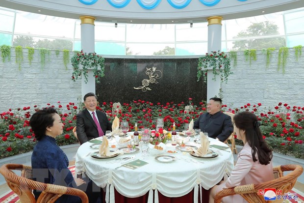 Nhà lãnh đạo Triều Tiên Kim Jong-un cùng phu nhân (phải) và Chủ tịch Trung Quốc Tập Cận Bình (thứ 2, trái) và phu nhân dự bữa tiệc trưa ở Bình Nhưỡng, ngày 21-6. (Ảnh: THX/TTXVN)