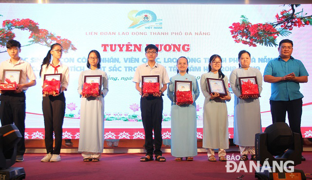 Phó chủ tịch Liên đoàn Lao động thành phố Trần Vũ Duy Mẫn (bìa phải) trao quà cho các học sinh xuất sắc. Ảnh: LAM PHƯƠNG.  