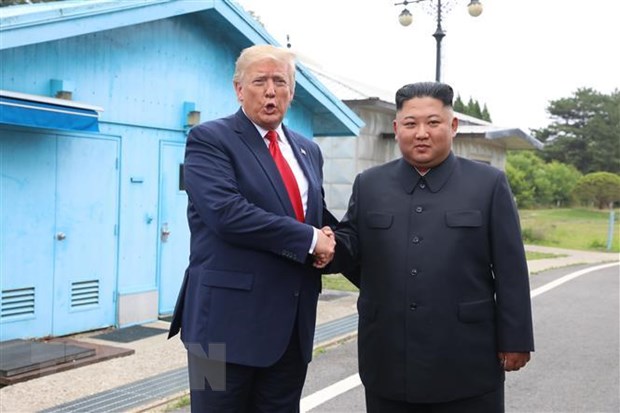 Tổng thống Mỹ Donald Trump (trái) và nhà lãnh đạo Triều Tiên Kim Jong-un trong cuộc gặp tại Khu phi quân sự (DMZ) ngày 30-6-2019. (Nguồn: THX/TTXVN)