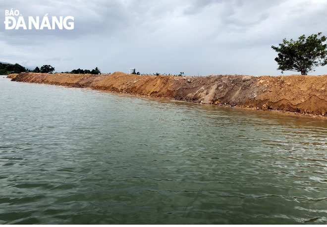 Việc đổ đất khiến lòng sông bị thu hẹp dòng chảy, có thể gây ngập lụt ở khu vực tổ 37 Thủy Tú.  Ảnh: NGỌC ĐOAN