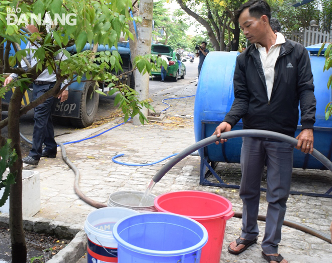 A person filling his containers with water from water supply tankers