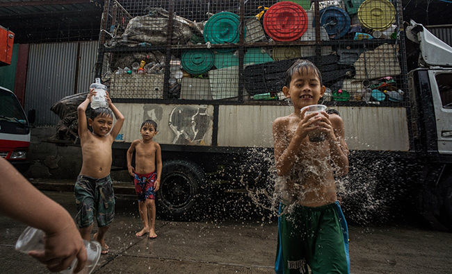 Những đứa trẻ chơi với rác thải nhựa ở làng Tây Canumay. Ảnh: The Guardian
