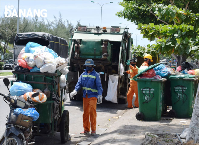 Công ty CP Môi trường đô thị Đà Nẵng huy động mọi nhân lực, phương tiện để thu gom, vận chuyển rác tồn đọng ở trung tâm thành phố.  Ảnh: HOÀNG HIỆP