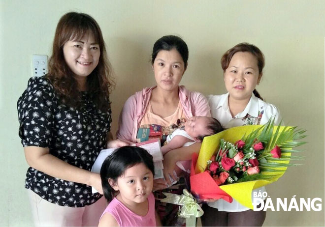 Cán bộ phường An Hải Bắc (quận Sơn Trà) trao thủ tục “3 trong 1”, tặng hoa, thư chúc mừng cho công dân mới chào đời. Ảnh: Trọng Huy