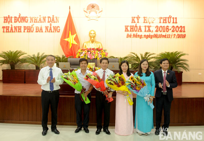 Ủy viên Trung ương Đảng, Bí thư Thành ủy, Trưởng Đoàn đại biểu Quốc hội thành phố Trương Quang Nghĩa (trái) và Chủ tịch HĐND thành phố Nguyễn Nho Trung (phải) tặng hoa cho các cá nhân.  					              
