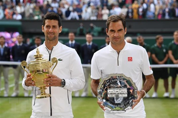 Phút đăng quang vô địch Wimbledon 2019 của Novak Djokovic (trái) sau khi thắng kịch tính Roger Federer (phải) tại London, Anh ngày 14-7-2019. (Ảnh: AFP/TTXVN)