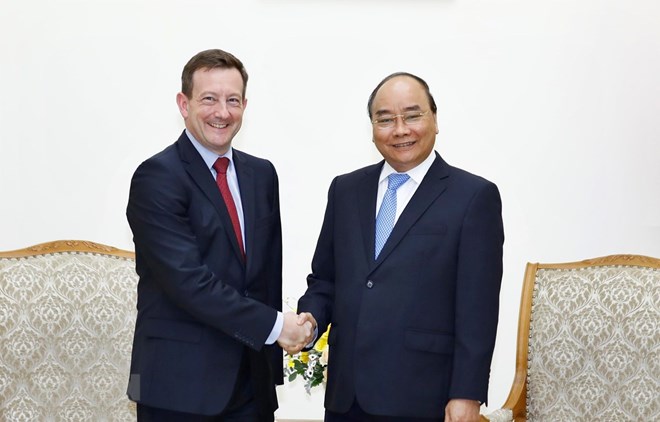 Prime Minister Nguyen Xuan Phuc (R) and outgoing French Ambassador to Vietnam Bertrand Lortholary at their meeting in Hanoi on July 17 (Photo: VNA)