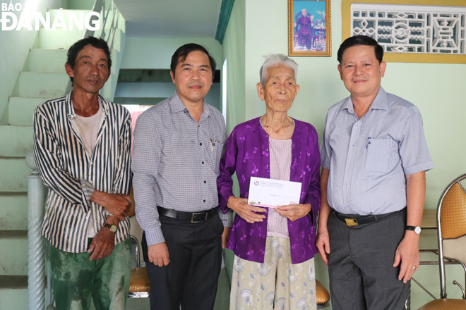 Mr Hong (first right), Mr Nam (second left) presenting 5 million VND to Mrs Nguyen Thi Ke