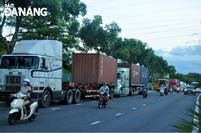 Rất nhiều xe container xếp hàng chờ hết giờ cấm để lưu thông trên đường Ngô Quyền.   Ảnh: THÀNH LÂN.