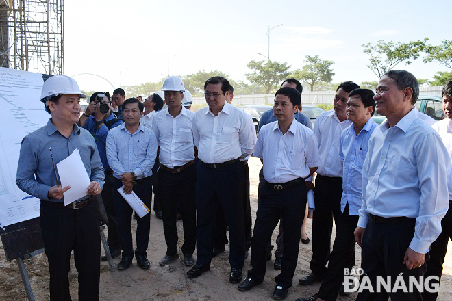 Bí thư Trương Quang Nghĩa lắng nghe nhà thầu báo cáo về tiến độ thi công công trình Trụ sở làm việc của Ban Quản lý Khu CNC và các KCN Đà Nẵng sáng 19-7.