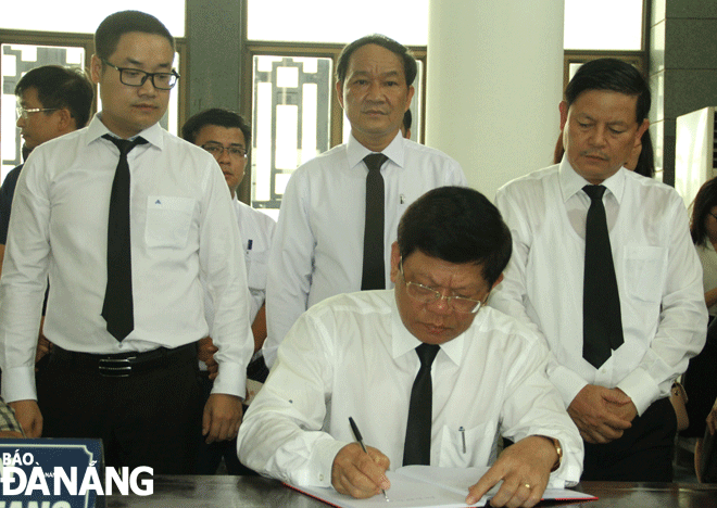 Deputy Secretary Tri writing in the funeral guest book