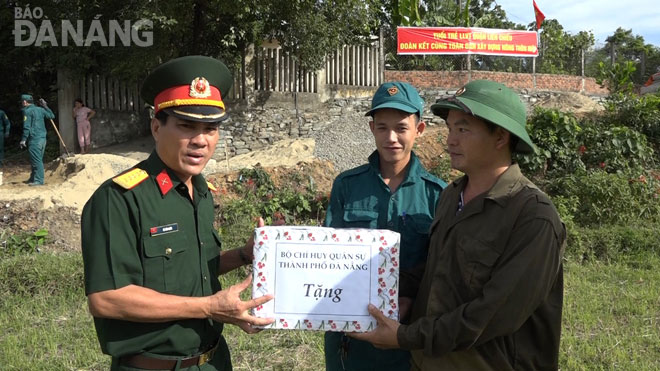 Thủ trưởng Bộ Chỉ huy Quân sự thành phố tặng quà động viên các đơn vị lực lượng vũ trang thành phố giúp nhân dân làm đường tại huyện Hòa Vang. 	               Ảnh: HỒNG HẠNH