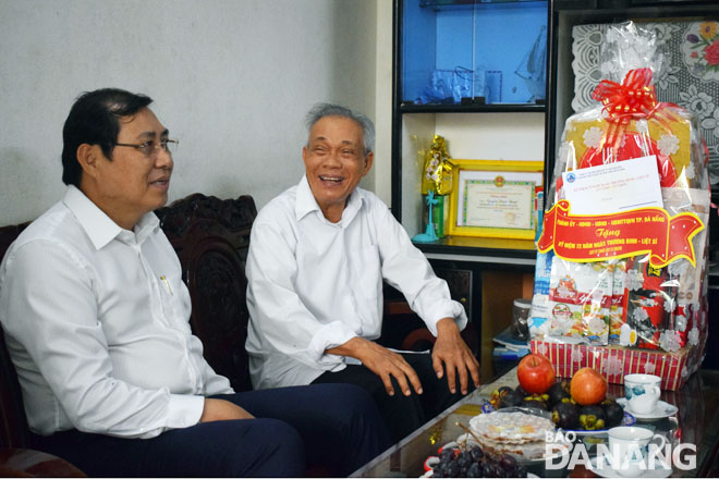 Chủ tịch UBND thành phố Huỳnh Đức Thơ (trái) thăm hỏi sức khỏe thương binh 2/4 Nguyễn Đình Thuật.  	     Ảnh: THANH SƠN