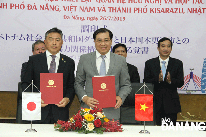 Chairman Tho (front row, right) and Mr Yoshikuni Watanabe (front row, left) at the signing ceremony