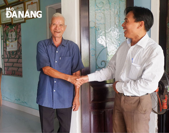 Ông Nguyễn Phú Mười (bên trái, ngụ thôn Yến Nê 2, xã Hòa Tiến) không giấu được niềm hạnh phúc khi ngôi nhà cũ vừa được “khoác áo mới”. 
