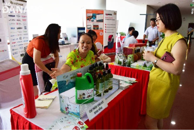 Mrs Trinh Thi Hong (centre), the Director of the Minh Hong Biology Company cum Secretary of the Party cell, introducing her products at a local fair