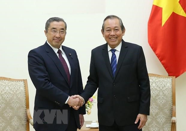 Deputy Prime Minister Truong Hoa Binh (R) welcomes Japanese State Minister of Internal Affairs and Communications Junji Suzuki (Source: VNA)