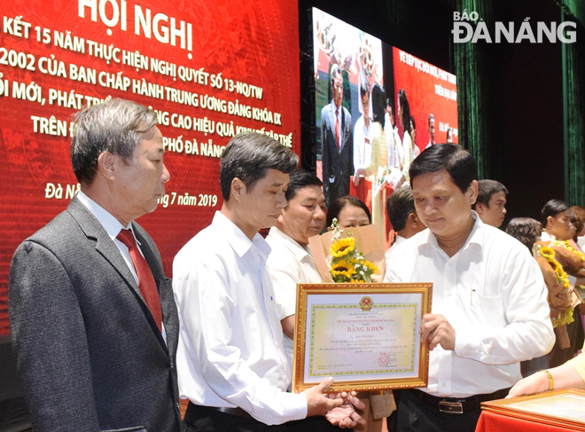 Chủ tịch HĐND thành phố Nguyễn Nho Trung (bìa phải) tặng bằng khen cho các cá nhân có thành tích xuất sắc trong 15 năm thực hiện Nghị quyết số 13-NQ/TW.