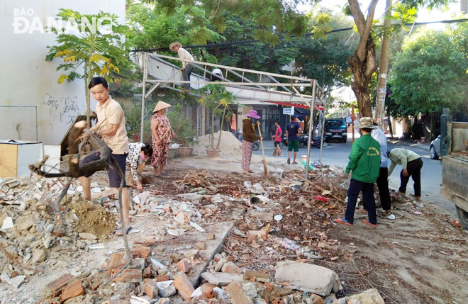 Người dân khu dân cư Bình An, thuộc phường Hòa Cường Nam dọn dẹp vệ sinh tại các lô đất trống. 
