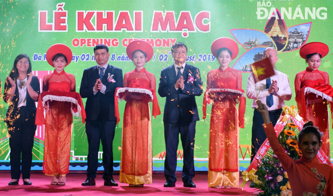 Phó Chủ tịch UBND thành phố Hồ Kỳ Minh (thứ 3, từ trái) tham gia cắt băng khai mạc Hội chợ EWEC tối 2-8.  Ảnh: KHÁNH HÒA
