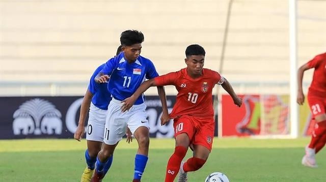 Vietnamese forward Cai Van Quy (R) holds off a Singapore player during their match in Group A (Photo: plo.vn)