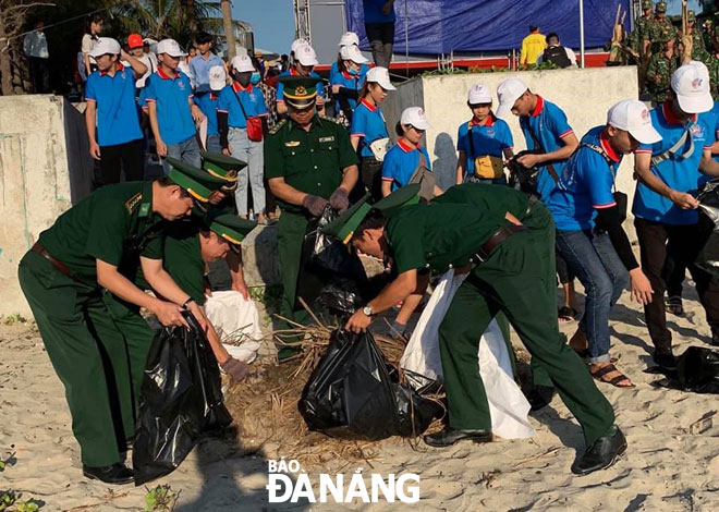 Cán bộ, chiến sĩ Đồn Biên phòng Non Nước tham gia dọn dẹp, thu gom rác thải tại bãi biển Ngũ Hành Sơn. 		                         		                  Ảnh: MAI THANH TÀI