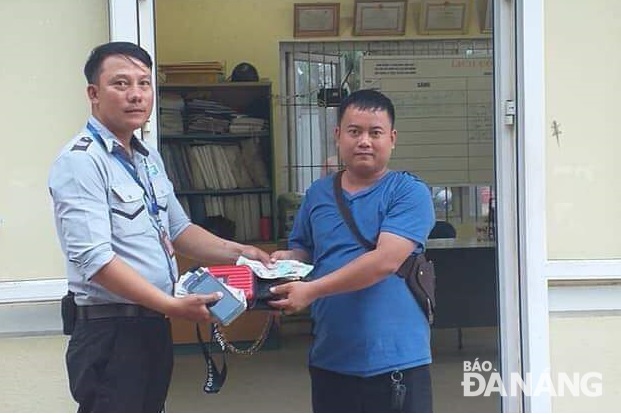 Mr Huong (left) returning the lost property to Mr Sysawa Khotmany