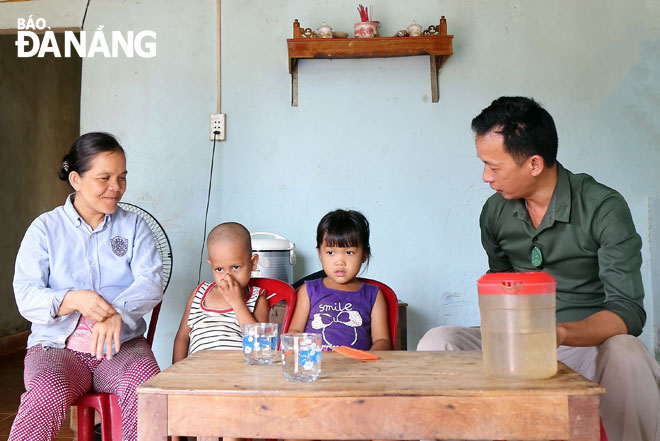 Chị Đinh Thị Khá (trái) chia sẻ hoàn cảnh gia đình mình với cán bộ xã Hòa Bắc. Ảnh: V.T.L