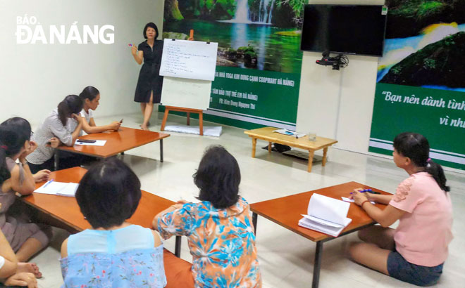 Các phụ huynh chăm chú nghe chuyên gia tâm lý, Phó Hiệu trưởng Trường tiểu học Hùng Vương (quận Hải Châu) Trần Thị Kim Hạnh chia sẻ về nguyên nhân của những bất thường thường thấy ở trẻ trong giai đoạn dậy thì. Ảnh: K.Q