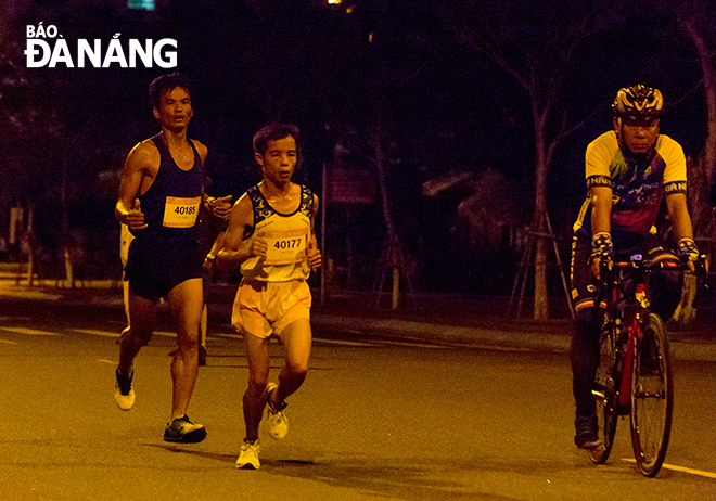 Vietnamese runner Le Tan Hi (in white) won the full marathon for men