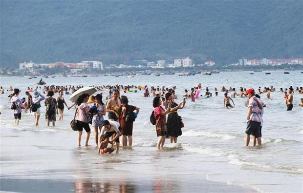 Du khách đến các bãi biển Đà Nẵng dạo chơi hóng mát giải nhiệt trong những ngày nắng nóng. (Ảnh: Trần Lê Lâm/TTXVN)