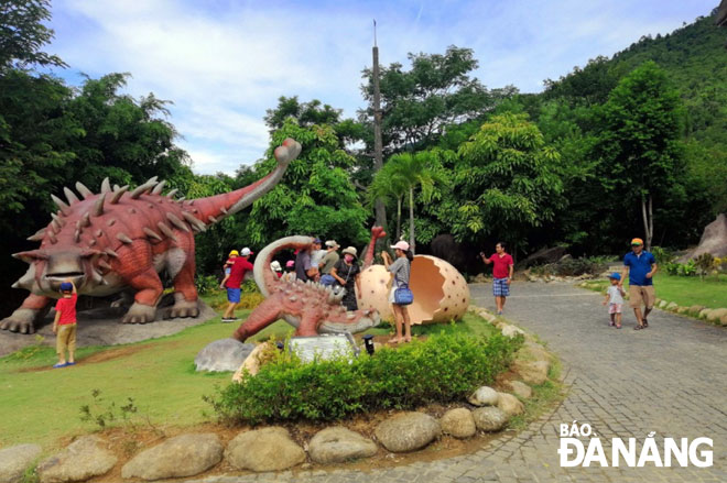 Các khu, điểm du lịch thường xuyên làm mới sản phẩm để thu hút khách.  TRONG ẢNH: Du khách tham quan, vui chơi tại Công viên khủng long trong Khu du lịch Suối khoáng nóng Núi Thần Tài.  				                  