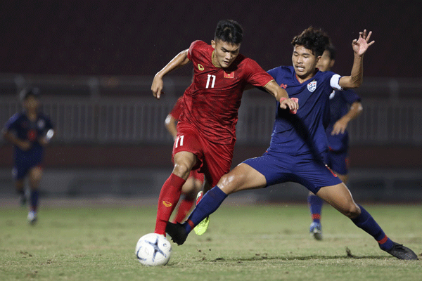 triker Võ Nguyên Hoàng of Việt Nam (left) runs away from a Thai defender during their Group B match of the ASEAN Football Federation U18 Championship. Photo courtesy of VFF Read more at http://vietnamnews.vn/sports/524009/viet-nam-tie-with-rivals-thailand-at-regional-u18-tournament.html#0r9PvTIeMMFL7Mke.99