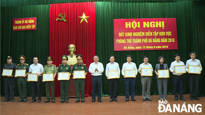Bí thư Thành ủy Trương Quang Nghĩa (giữa) tặng giấy khen cho các tập thể hoàn thành tốt nhiệm vụ diễn tập. Ảnh: Hồng Hạnh