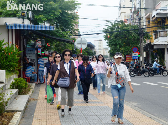 Apart from those taking self-guided tours, cruise ship passengers also like one-day city tours. A group of cruise ship tourists are seen leisurely strolling along a local street after their visits to the Rooster Cathedral and the Han Market.