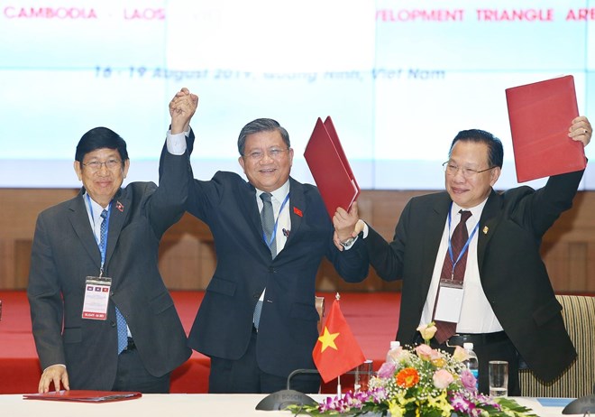 From left: head of the Lao National Assembly's external relations committee Eksavang Vongvichit; head of the Vietnamese National Assembly's external relations committe Nguyen Van Giau; and head of the committee for external relations, international cooperation, information and communications of the Cambodian parliament Chheang Vun celebrate after the joint statement was signed (Photo: VNA)