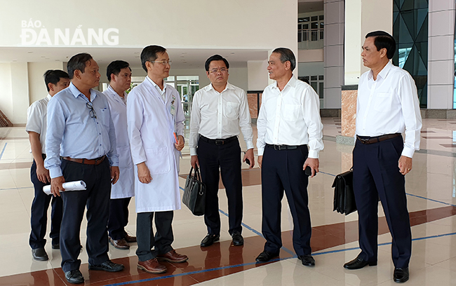 Secretary Nghia (2nd right) discussing with leaders of the Da Nang Cancer Hospital on the sidelines of the meeting