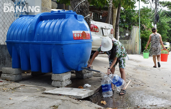 Người dân ở đường Nguyễn Đình Chiểu (quận Ngũ Hành Sơn) lấy nước từ các bồn chứa cấp nước bổ sung của Dawaco.