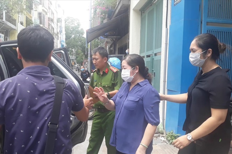 Nguyễn Thị Nguyên (trái) bị đưa khỏi Công ty TNHH TMDV Lữ hành Hòa Bình Quốc tế, sáng nay. Ảnh: Thành Nguyễn.
