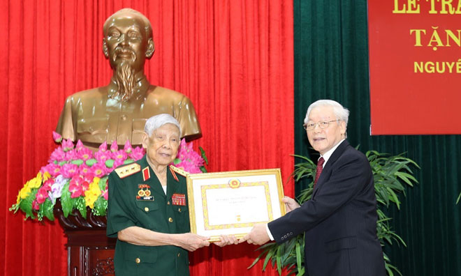 Tổng Bí thư, Chủ tịch nước Nguyễn Phú Trọng, Bí thư Quân ủy Trung ương trao Huy hiệu 70 năm tuổi Đảng tặng đồng chí Lê Khả Phiêu. Ảnh: TTXVN