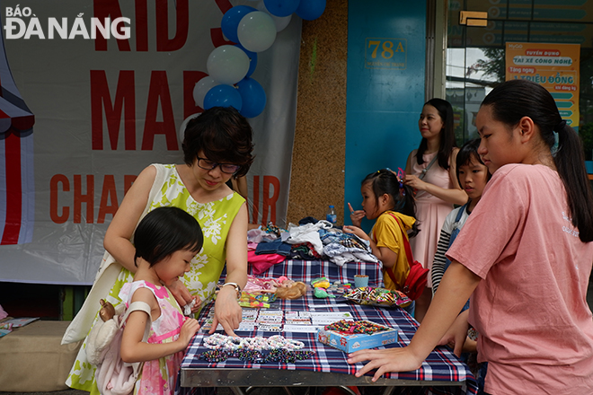 Chị Lê Nguyễn Nguyên Hạ (ngụ quận Thanh Khê) cùng cô con gái lớn ghé đến chương trình Kids Mart, mua hàng ủng hộ các bạn nhỏ.