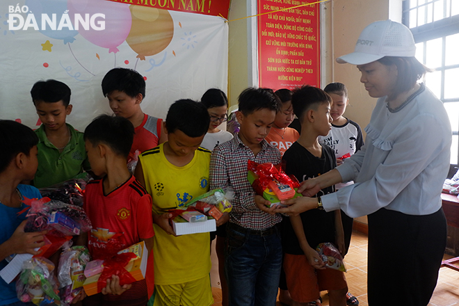Chị Đồ Thị Tường Vi, người đồng sáng lập An Phú Farm tặng quà cho các bạn nhỏ tại thôn Cẩm Nê, xã Hòa Tiến.