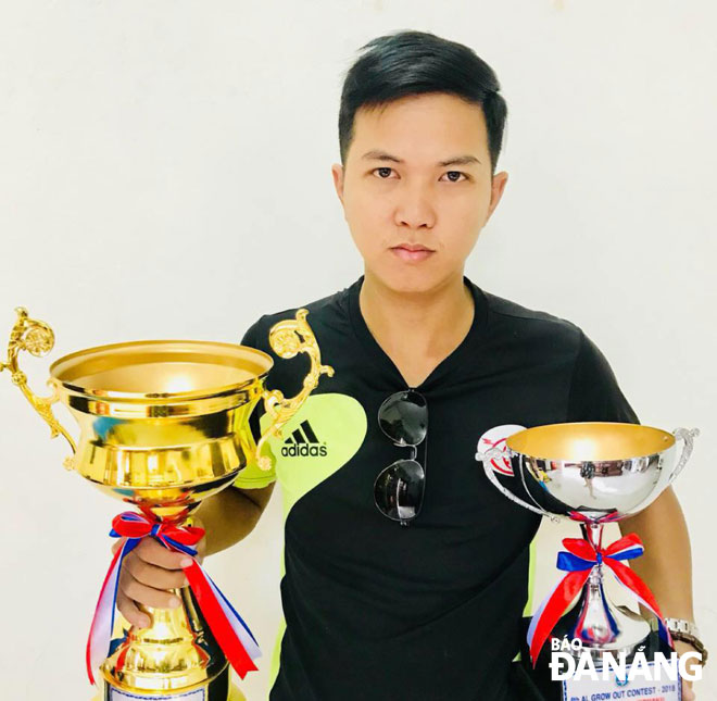 Phi holding 2 trophies presented by the Viet Nam Koi Breeding Association