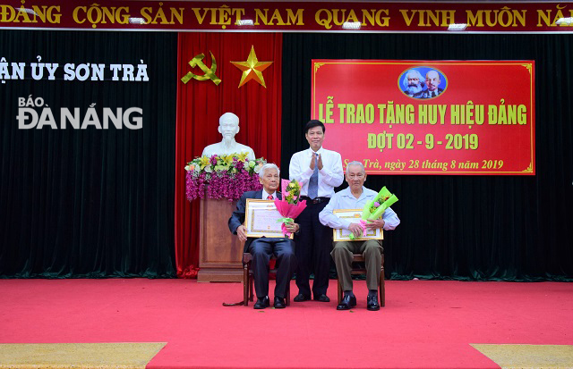 Trưởng Ban Dân vận Phạm Quý trao huy hiệu 70 năm tuổi Đảng cho đảng viên Đảng bộ quận Sơn Trà. Ảnh: TRỌNG HUY