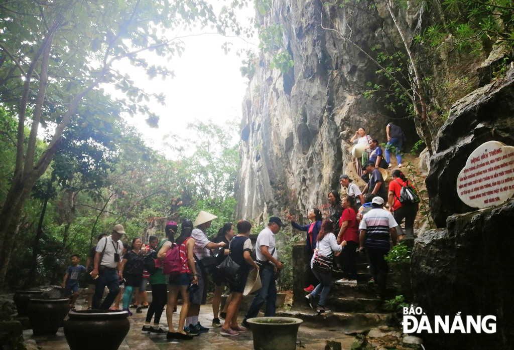 Buổi chiều 1-9, thời tiết có mưa nhưng tại khu du lịch thắng cảnh Ngũ Hành Sơn vẫn rất đông du khách quốc tế đến tham quan. Trong ảnh, du khách xếp hàng lên động Vân Thông.